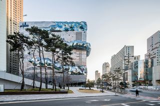 A building designed to look like a rock face with bubbles of triangular windows wrapping around it.