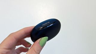 Realme Buds Air 3 review: headphones charging case in hand with green nails