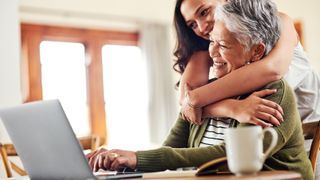 An older lady using a laptop with her daughter