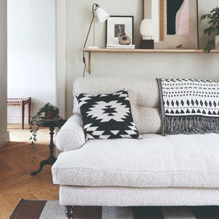 A small living room with a cream sofa and matching walls