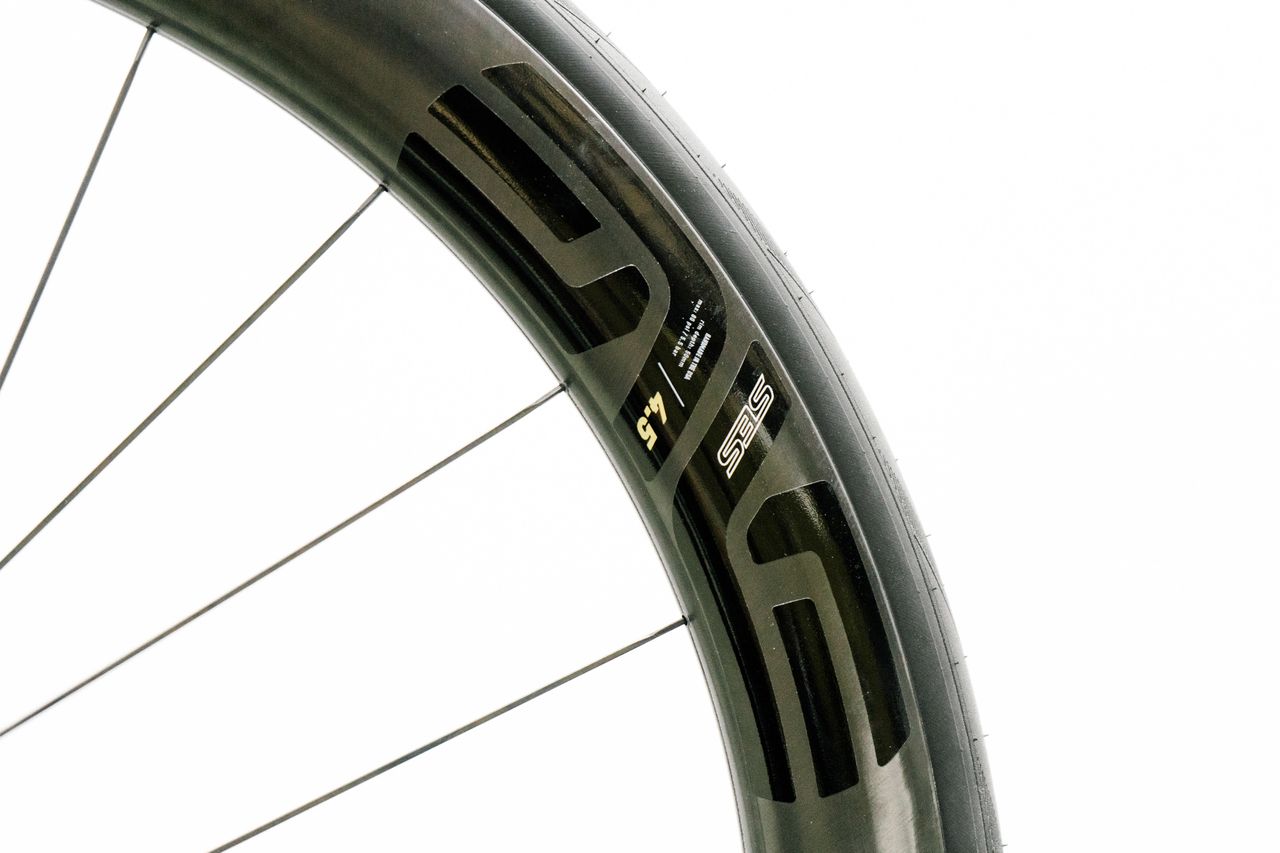 An aero road wheel stands against a white wall