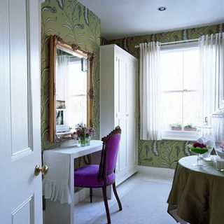 dressing room with purple chair and wallpaper wall and mirror