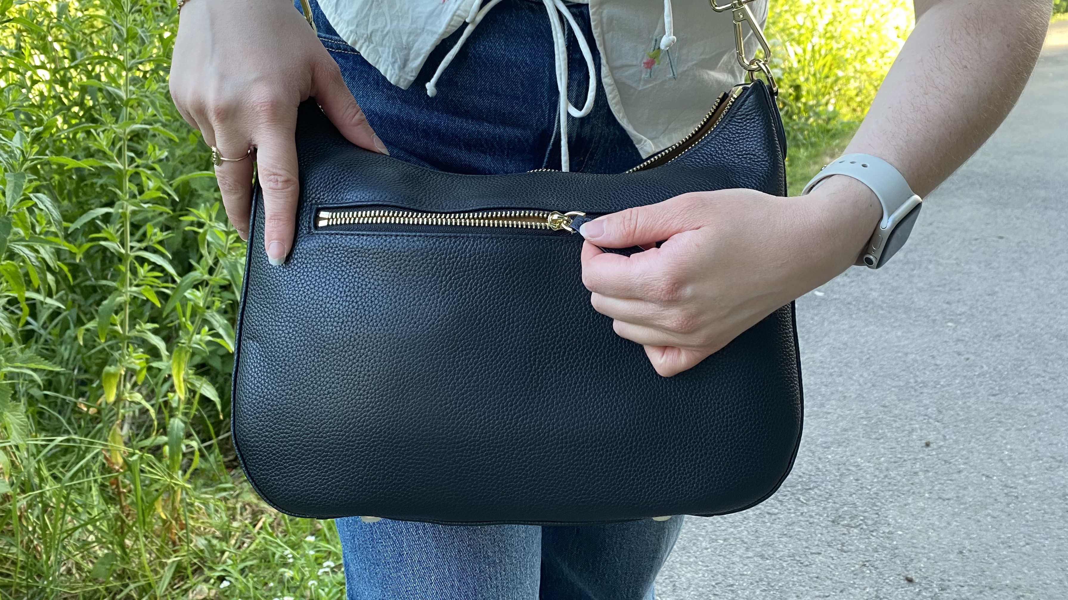 Person wearing a Voygr 1 camera bag opening zip