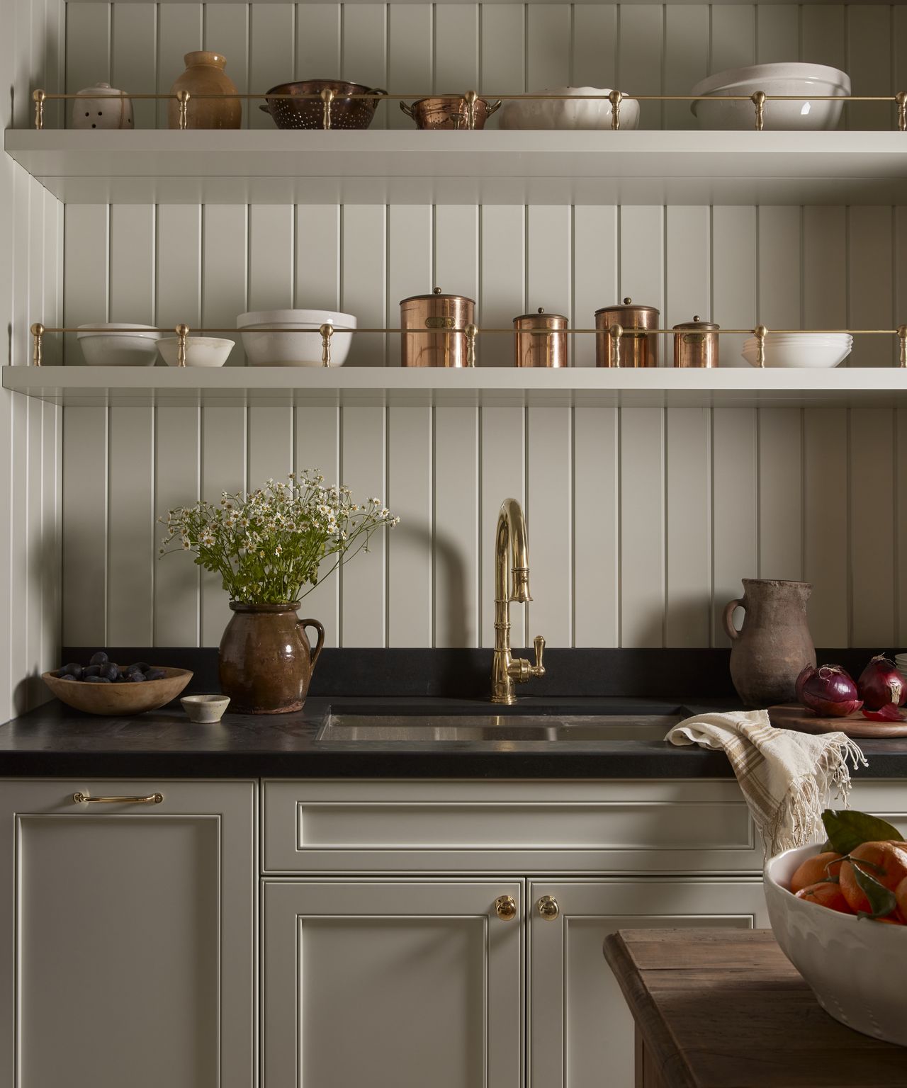 white kitchen with white bowls and copper canisters on open shelves