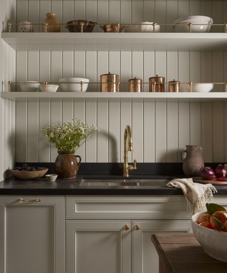 white kitchen with white bowls and copper canisters on open shelves