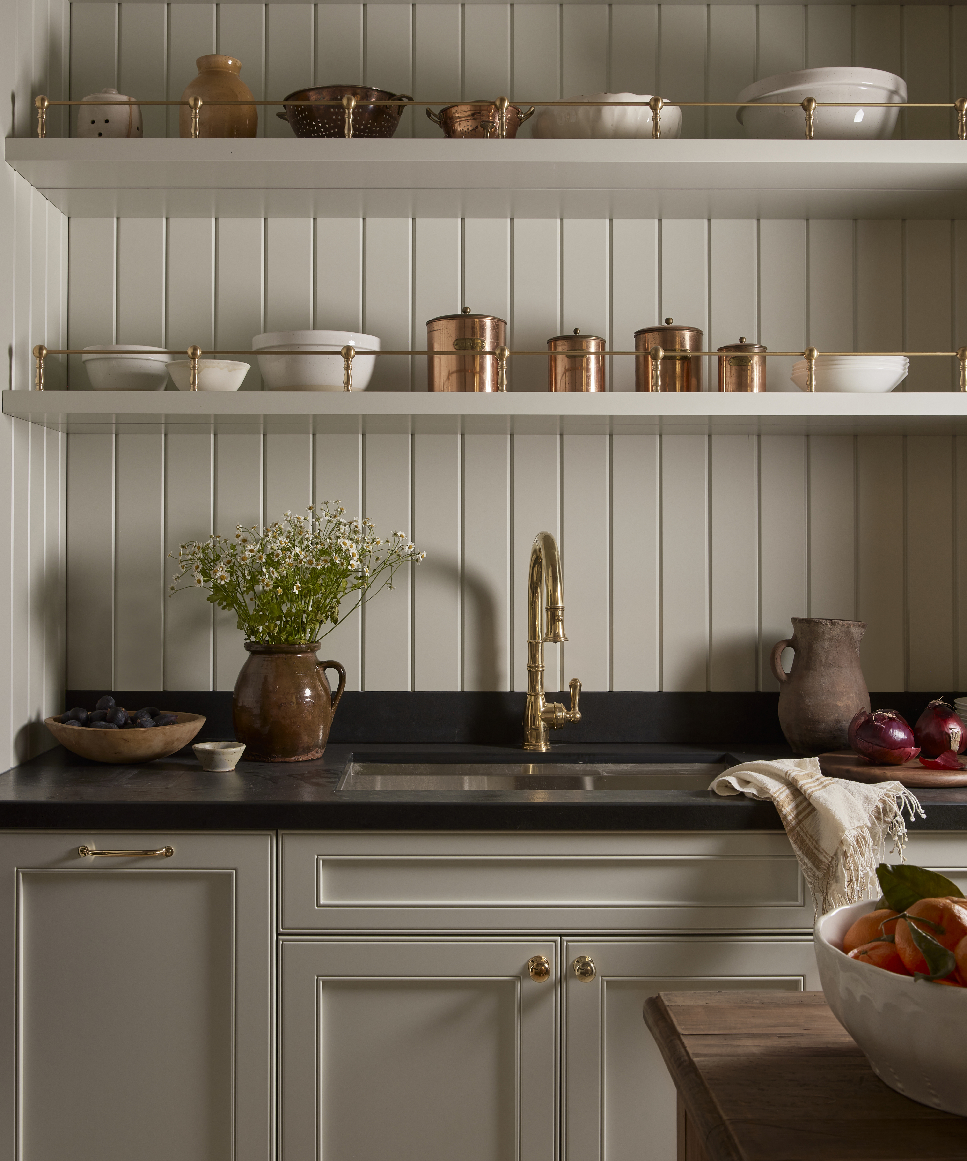 white kitchen with white bowls and copper canisters on open shelves