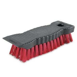 A flat black brush with ridges and red bristles