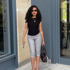 Influencer wears gingham capri pants.