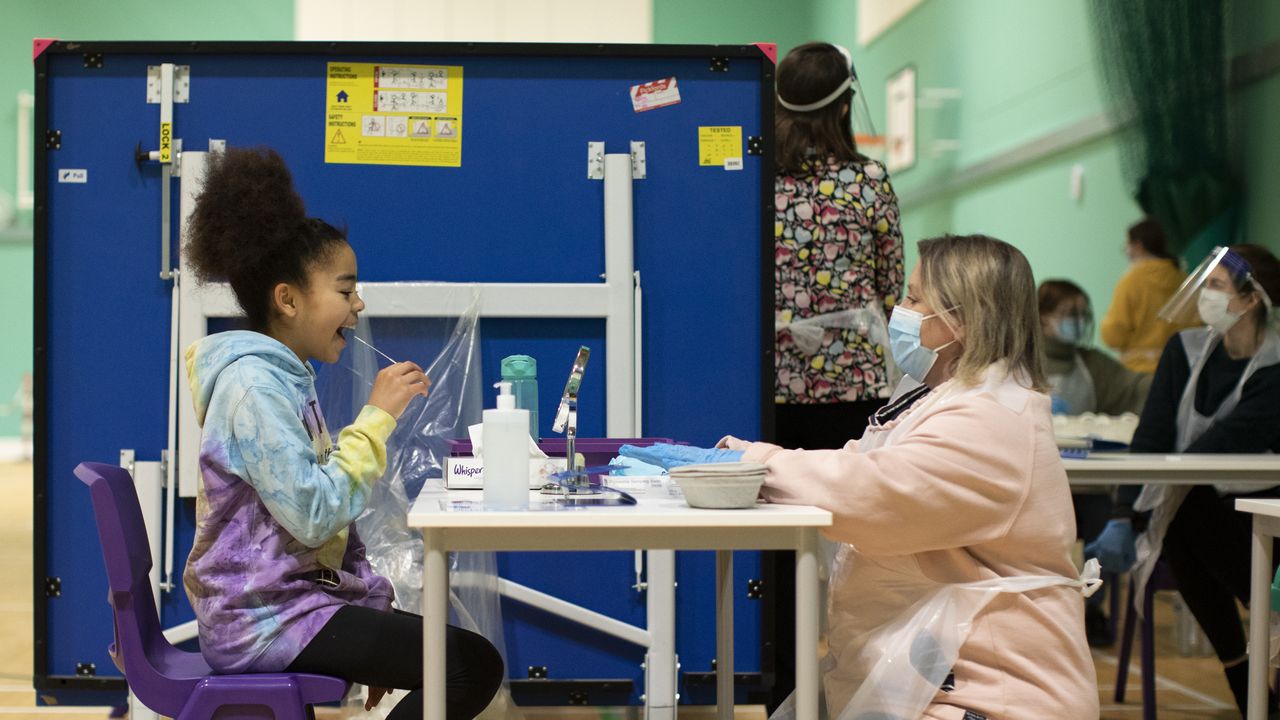 A student uses a lateral flow test under the supervision of a staff member.