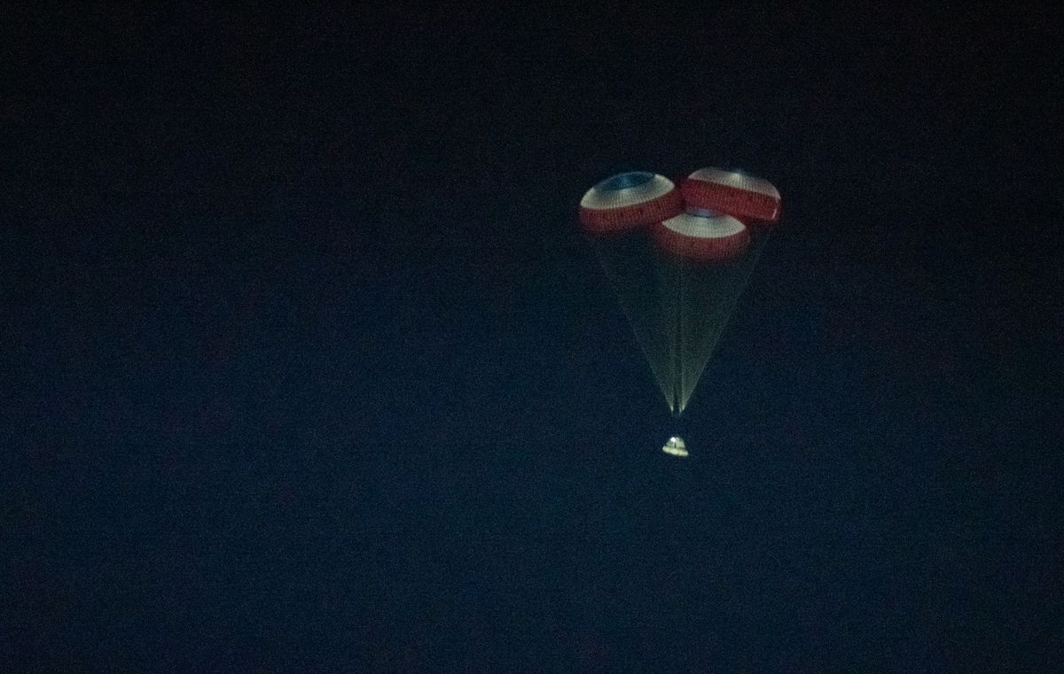 Boeing's first Starliner spacecraft parachutes back to Earth for a successful landing at White Sands Space Harbor in New Mexico on Dec. 22, 2019.