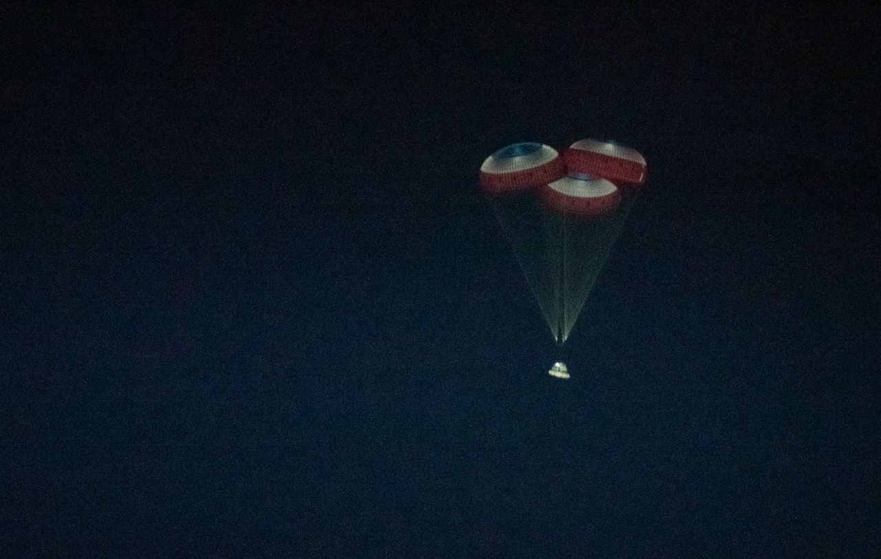 Boeing's first Starliner spacecraft parachutes back to Earth for a successful landing at White Sands Space Harbor in New Mexico on Dec. 22, 2019.