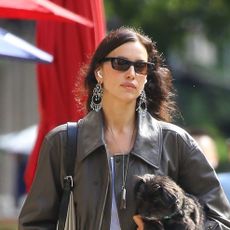 Irina Shayk wearing a brown leather bomber jacket, cream jeans, and cream fur ballet flats in NYC