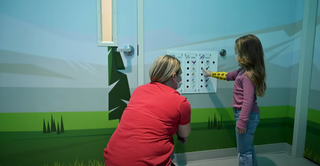 A child picks the interactive experience as she prepares to enter the doctor's office.
