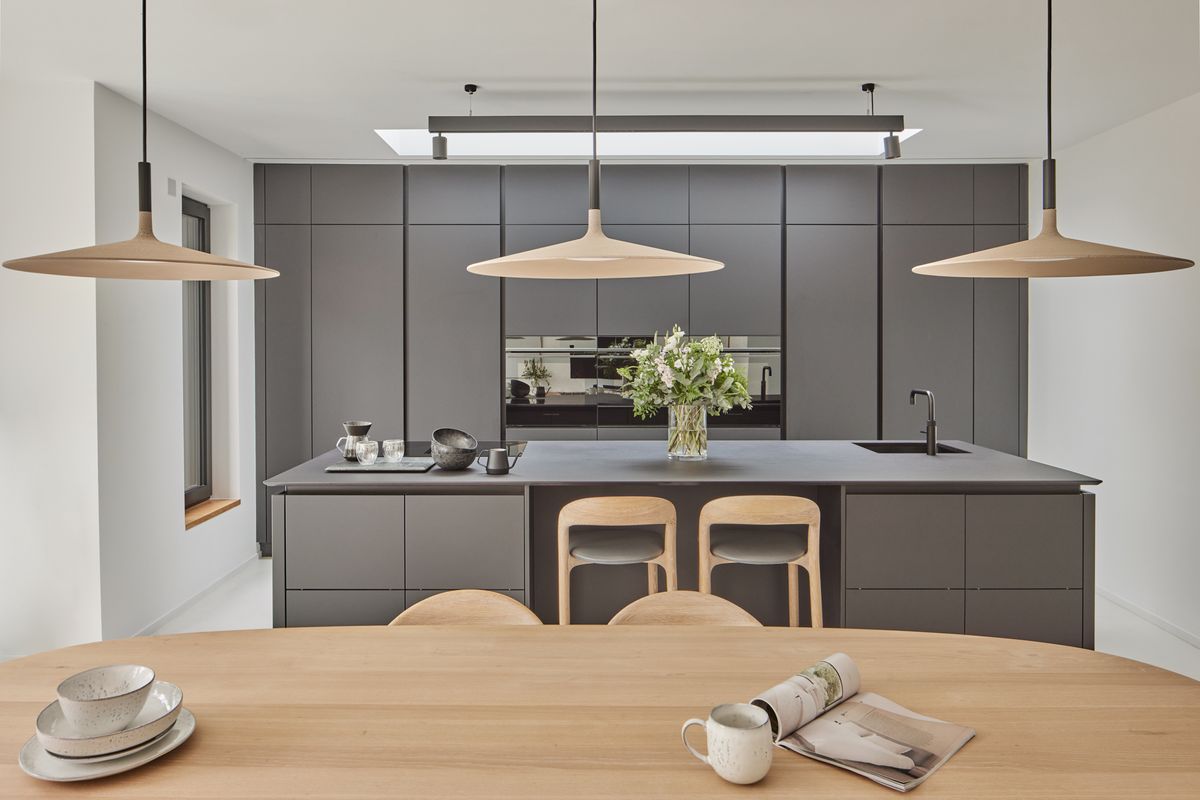 A modern black kitchen with pendant lighting and an island