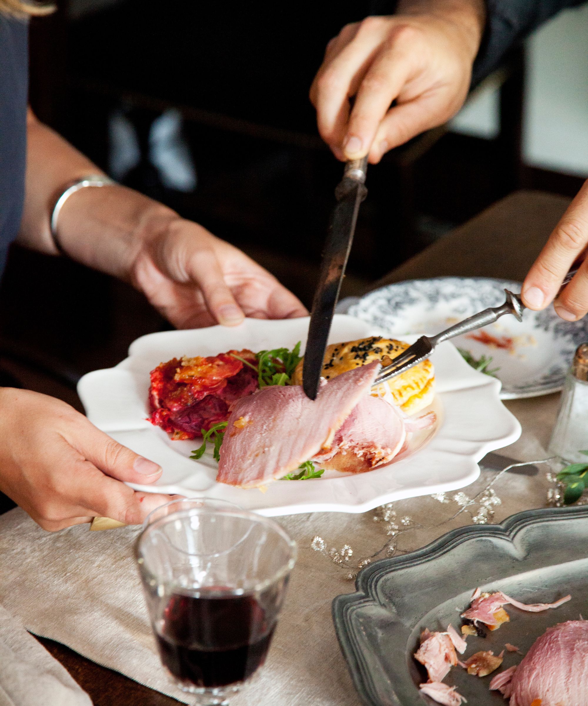Serving ham onto a plate for Christmas lunch