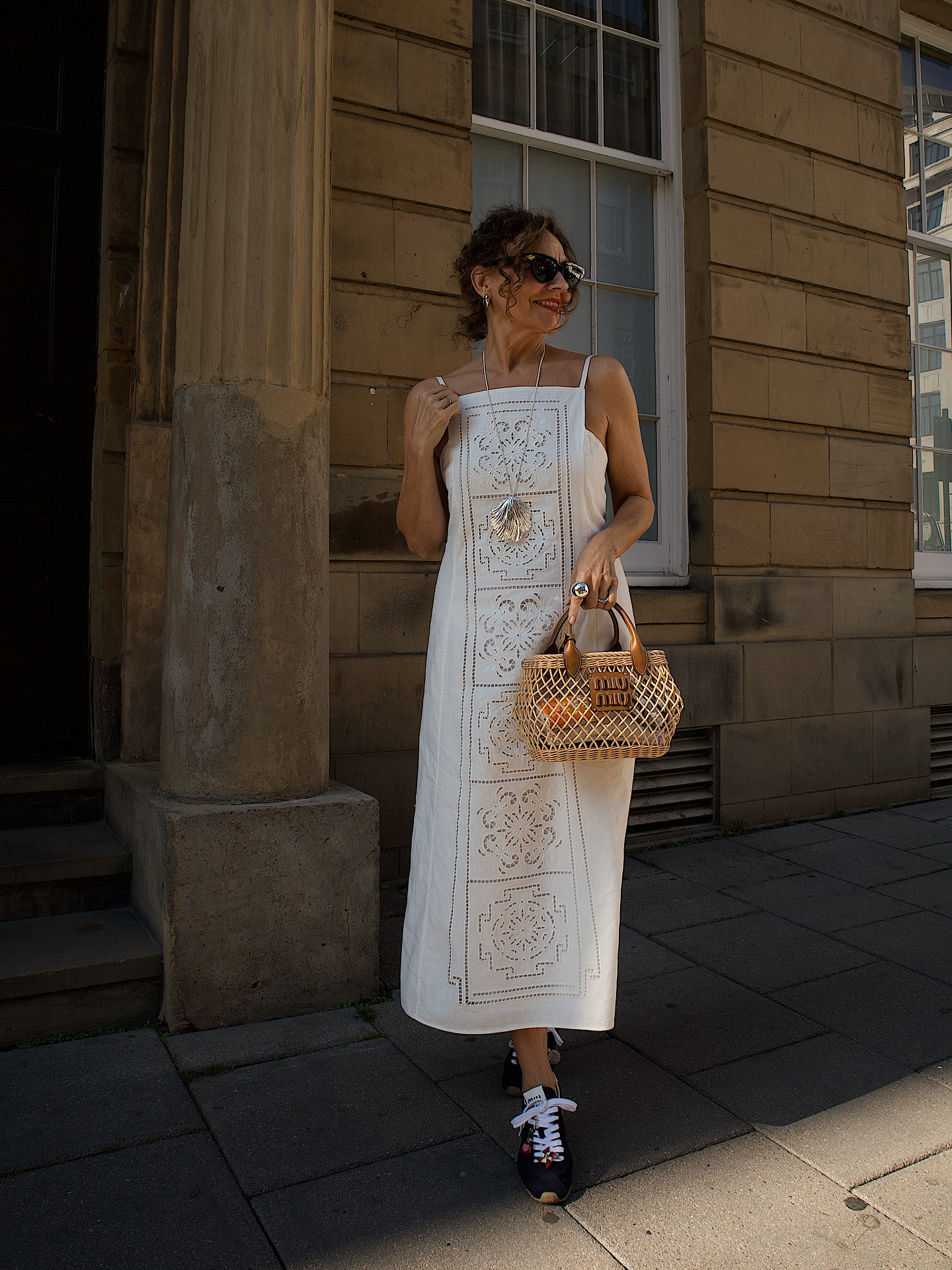 An image of @venswifestyle wearing slimline trainers from Miu Miu with a broderie anglaise dress.