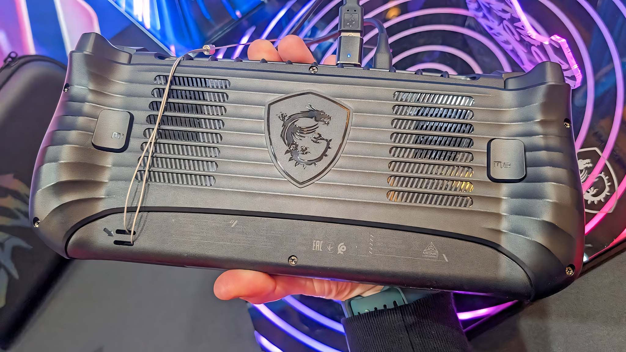 The backside of the MSI Claw 8 AI+ being held up by a hand. 