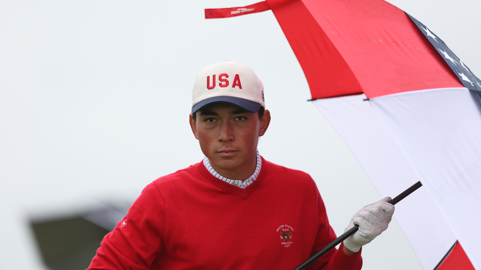 Kihei Akina holds an umbrella during the Walker Cup