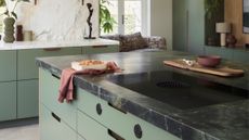 a back leathered kitchen countertop in a light green kitchen
