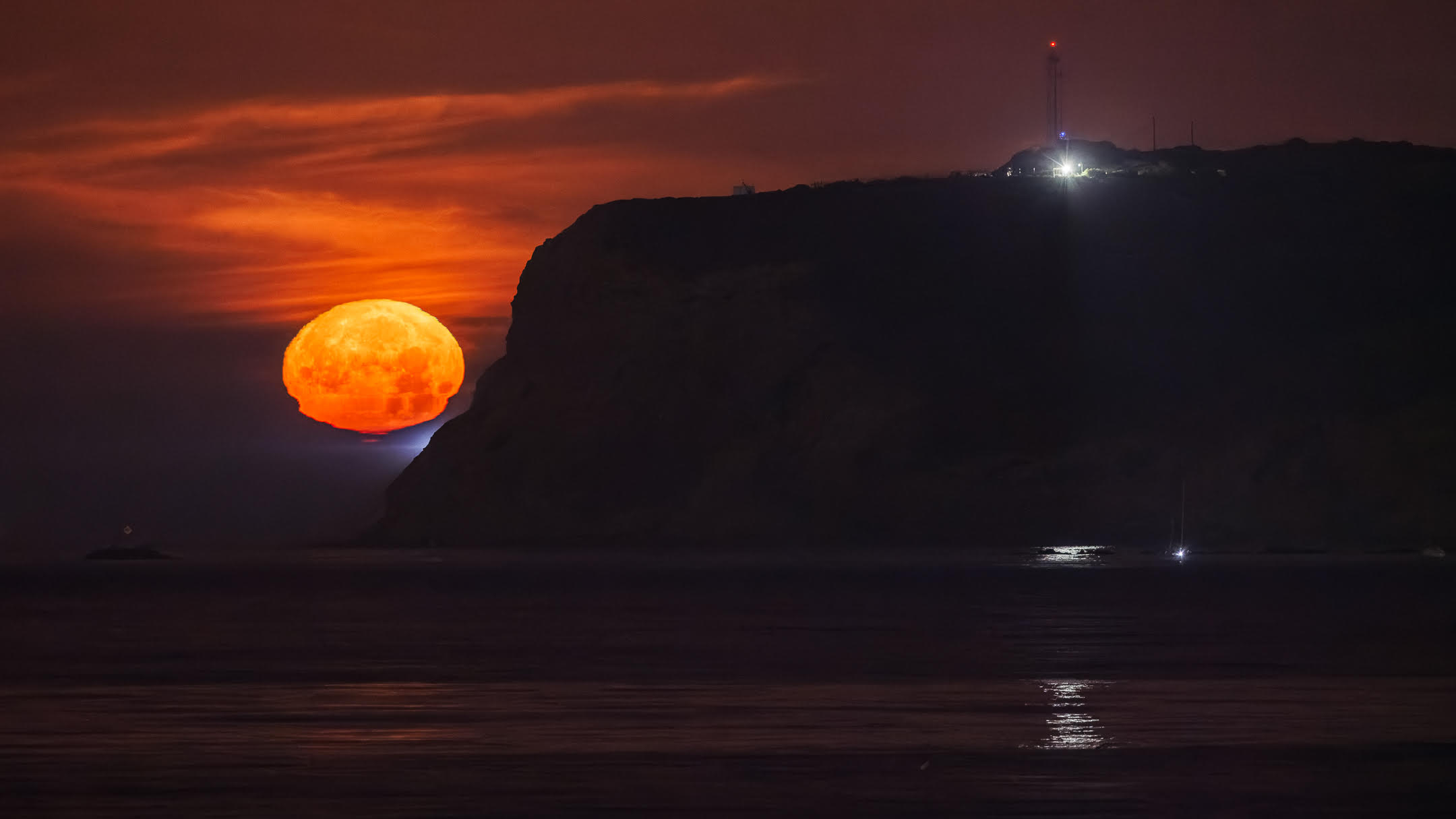 The May 2025 full Flower Moon is pictured setting alongside Point Loma peninsula in California on May 11