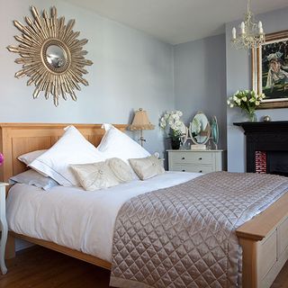 bedroom with cream and white bedlinen cushions and mirror