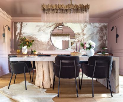 A pink dining room with a feature wall of wallpaper