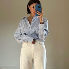 woman in blue button-down and white jeans