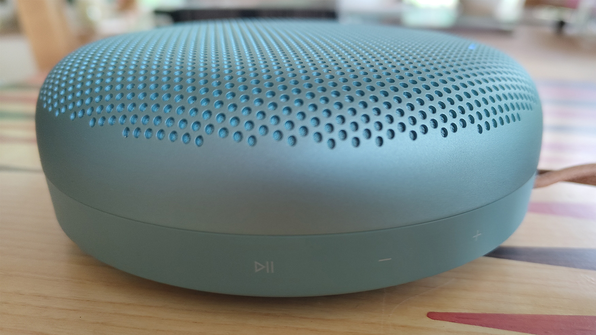 Bang & Olufsen Beosound A1 (3rd Generation) wireless speaker on wooden table, side view