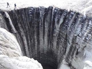 During the annual drainage of an ice-dammed lake, water runs through this large moulin on Plaine Morte glacier to the glacier bed.
