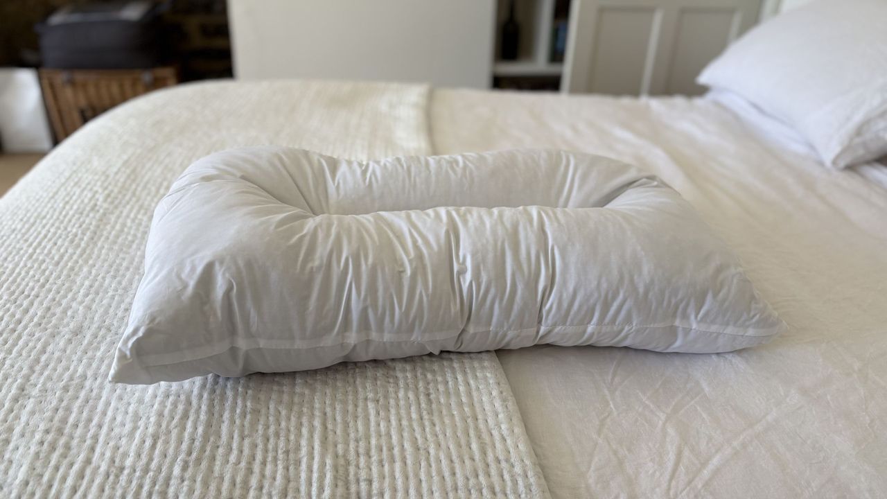 The Naturalmat The Centre Stitched Wool Pillow on a bed