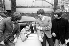 John Lennon passes his driving test in February 1965, with Paul McCartney Ringo Starr and George Harrison there to congratulate him. (Photo by Eyles/Daily Herald/Mirrorpix via Getty Images)