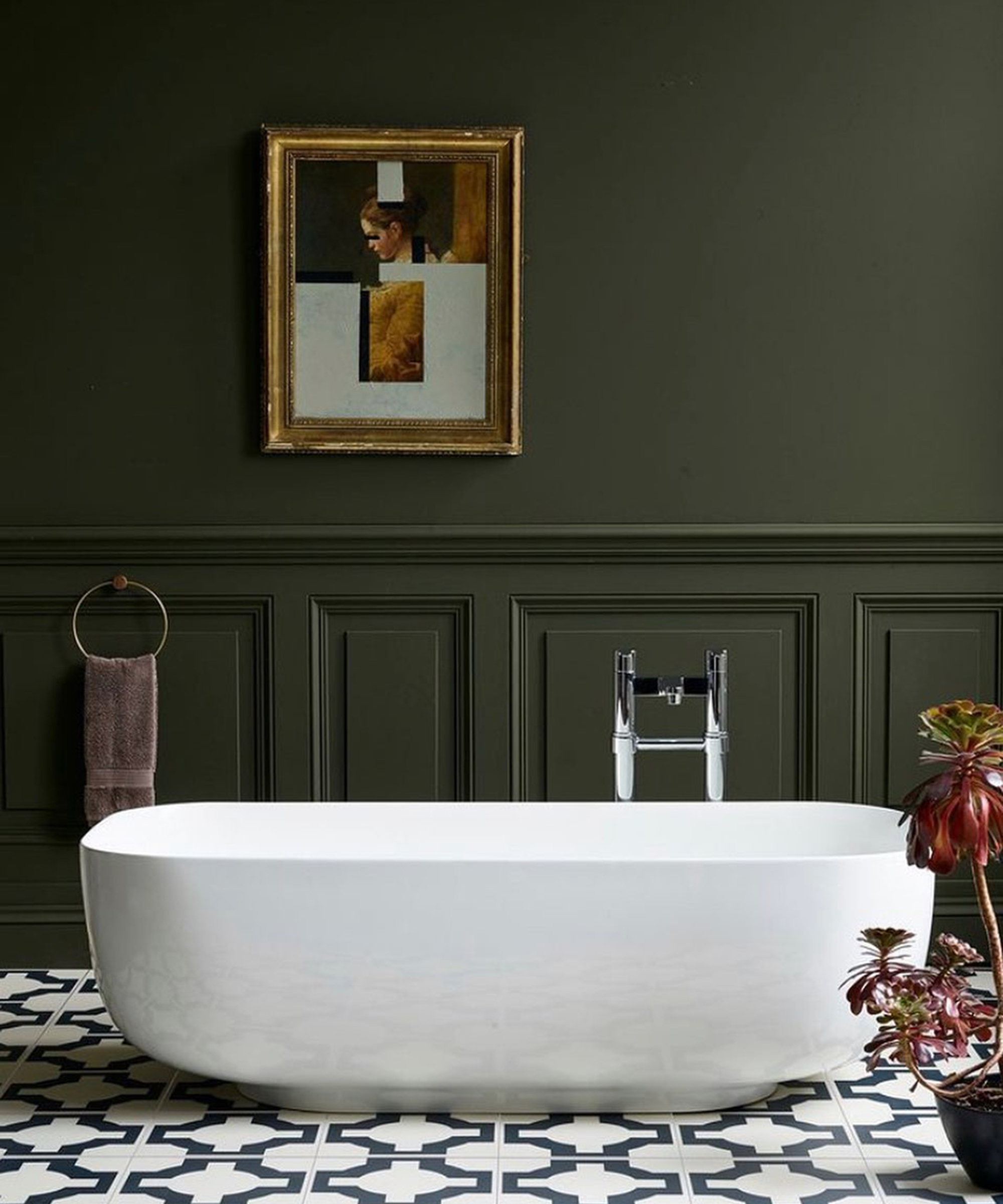 Khaki bathroom with wall paneling, freestanding white bath and framed wall art by Blue Sky Bathrooms