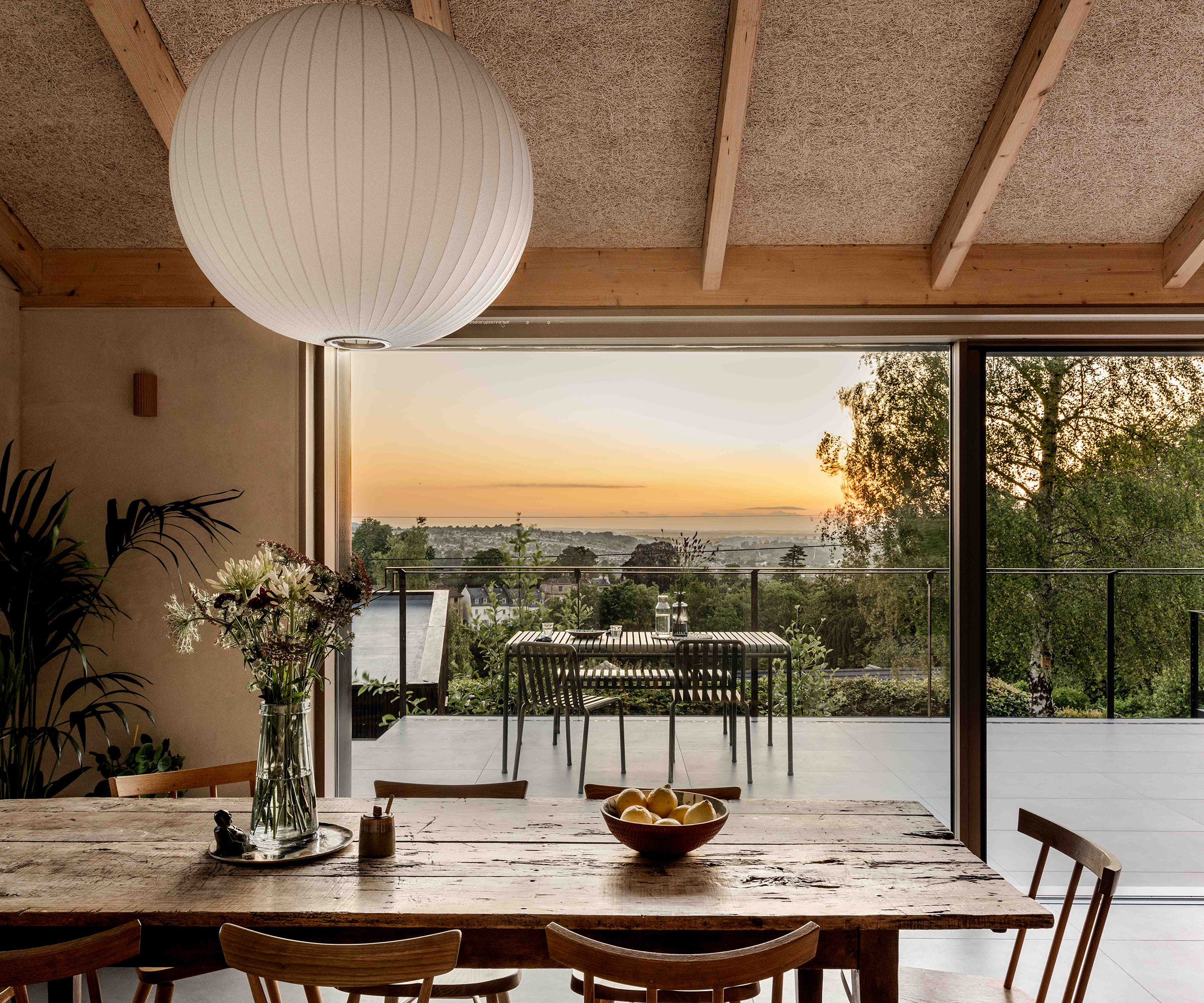 View across a dining table to a sunset terrace