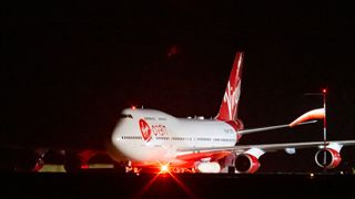 View of cosmic girl preparing to take off. The red and white plane is branded with Virgin Orbit logos.