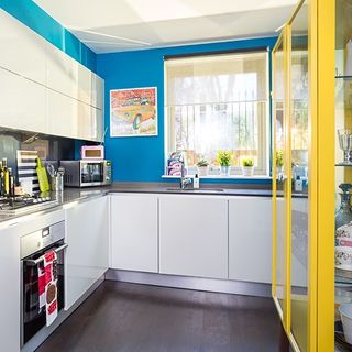 kitchen with wooden floor and blue wall and white cabinets