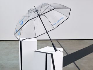 Transparent umbrella on a white block installation