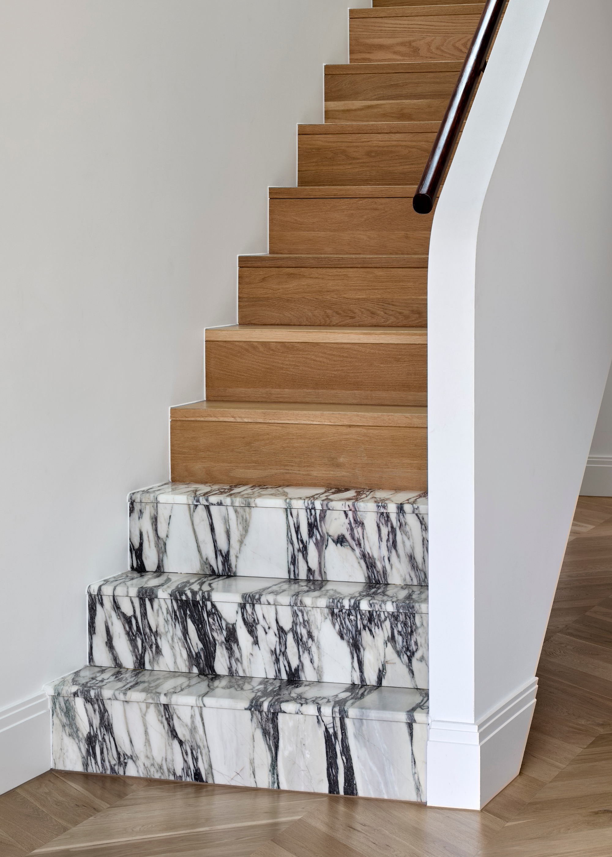 A wooden staircase with three stone steps at the base
