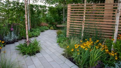 plank style paving in a modern garden with slatted privacy fence