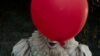 A clown hides under a red balloon in Stephen King&#039;s It