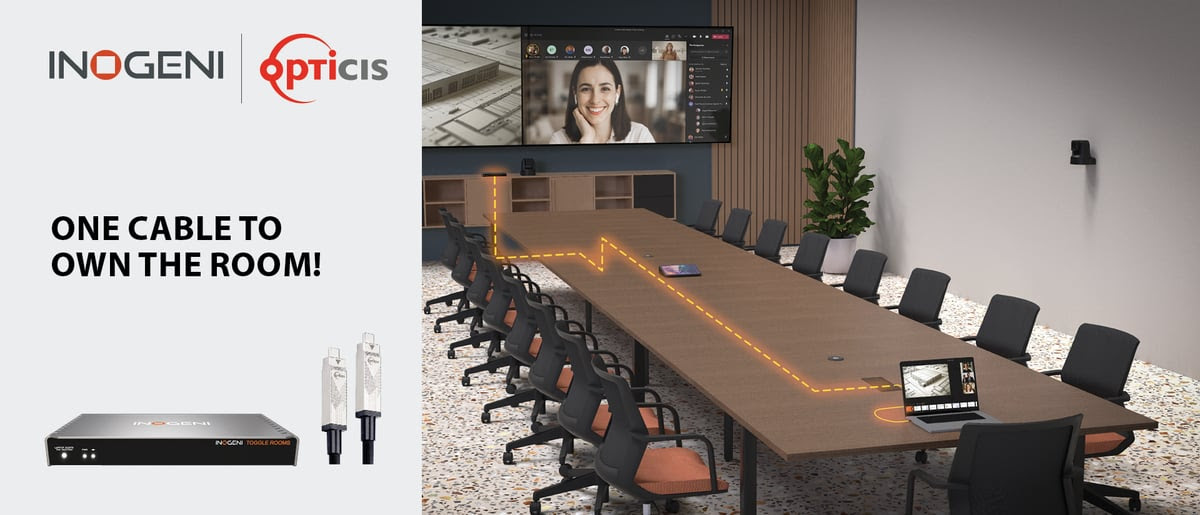 An image of a board room with a long, empty conference table and technology for videoconferencing.