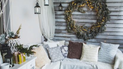 Balcony Christmas decor festive balcony with panelled walls, a big wreath and soft cushions and throws