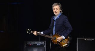 Sir Paul McCartney rocks the London O2 crowd in 2024 and gives them a sly glance as he plays his iconic Hofner 500/1 bass.