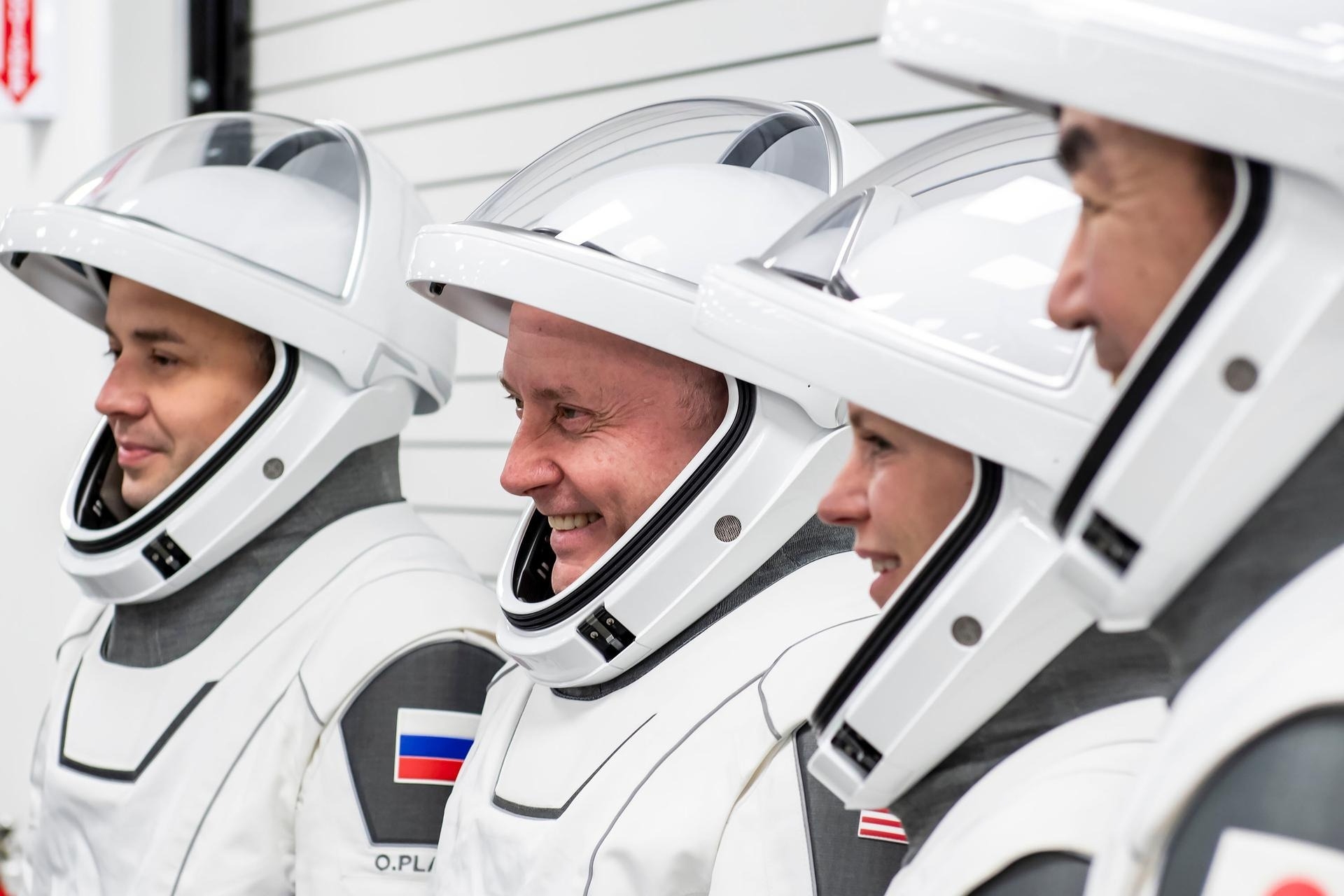 astronauts in white spacesuits pose for portraits