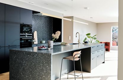 kitchen island in a large black and beige kitchen
