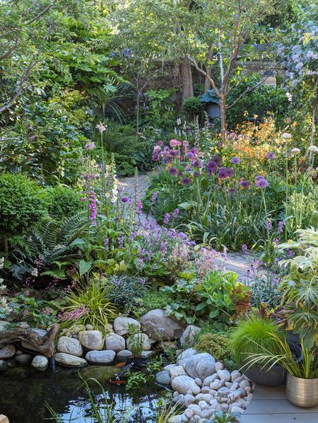 A city woodland inspired garden with water feature and gravel curved path leading through the garden.