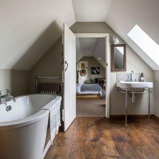 Attic bathroom with bathtub and wooden flooring
