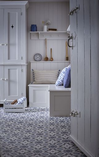 white mudroom/bootroom with patterned blue floor tiles