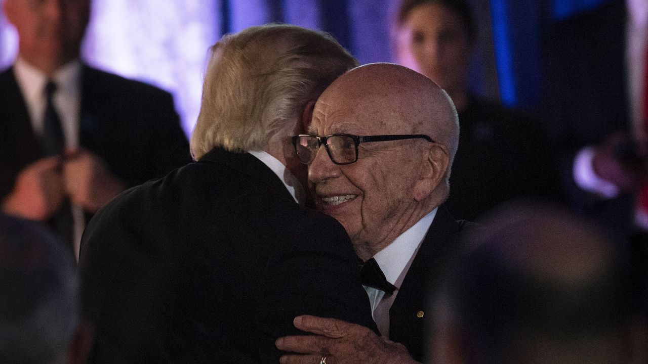 Donald Trump and Rupert Murdoch embrace at a dinner to commemorate the 75th anniversary of the Battle of the Coral Sea.