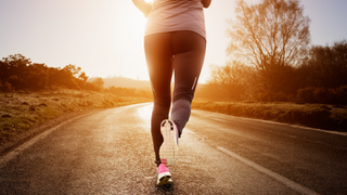 Woman going on a run along road in countryside