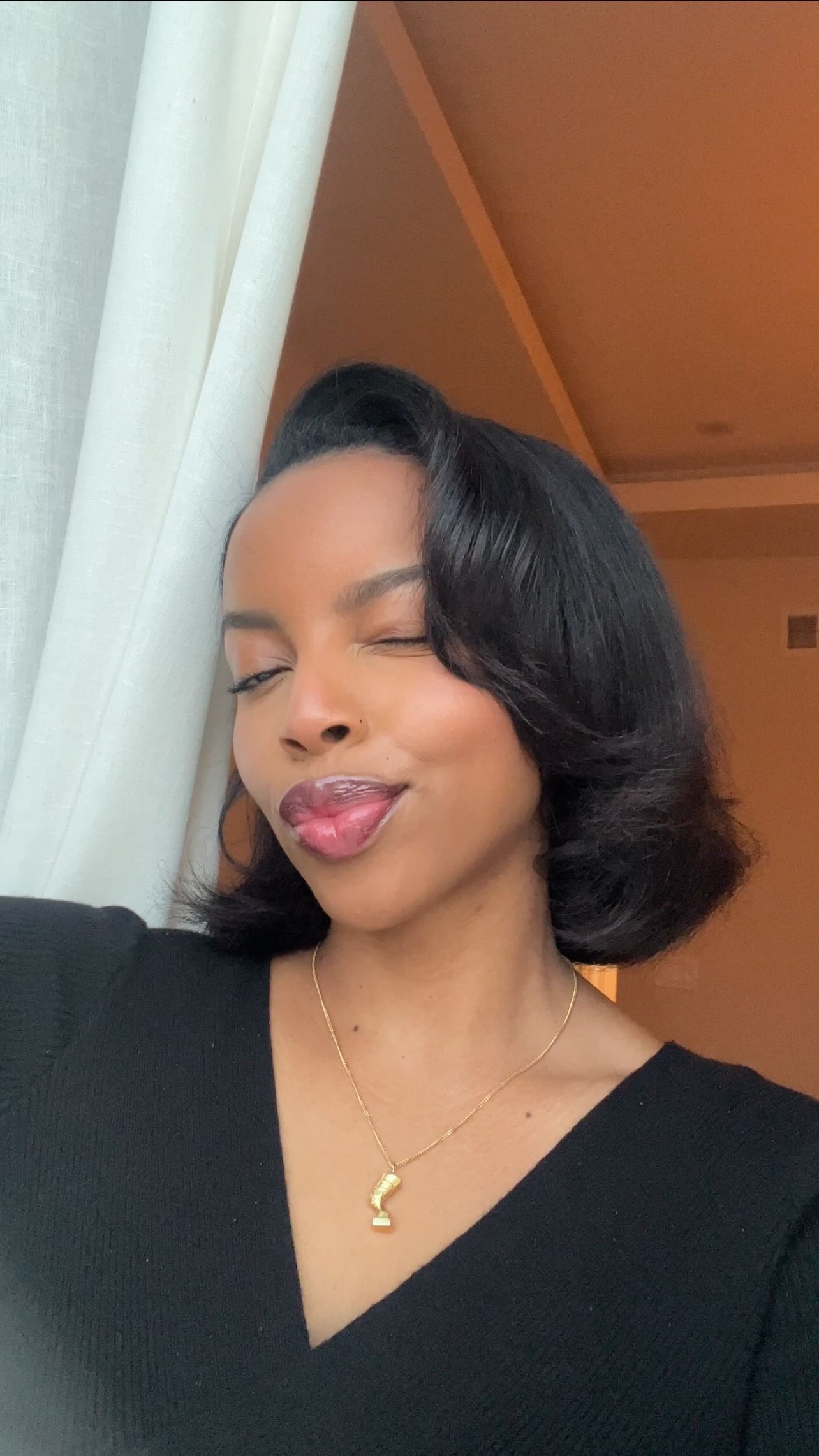 Aysha takes a selfie wearing a side part.